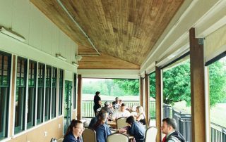 Guests dining on the covered outdoor deck at Terrazza Greenfield with golf course views
