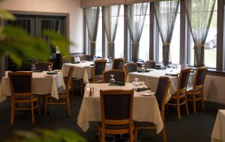Round and rectangular tables set with white linens in Terrazza Greenfield's banquet room