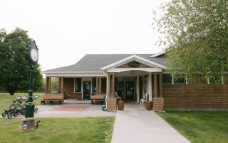 Exterior view of Terrazza Greenfield restaurant building with vintage clock, golf carts, and covered porch entrance