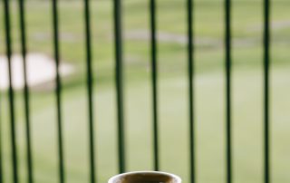 Espresso cup with lemon peel served on the outdoor deck at Terrazza Greenfield with golf course view