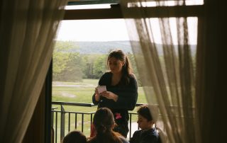 Server taking guests' order on the scenic outdoor deck at Terrazza Greenfield with mountain views