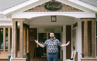 Man welcoming guests with open arms at the entrance of Terrazza Italian Restaurant in Greenfield