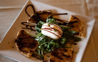 Grilled flatbread appetizer with fresh greens and balsamic drizzle served at Terrazza Greenfield restaurant