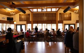 Guests dining at tables inside Terrazza Greenfield restaurant with staff and bar area in view