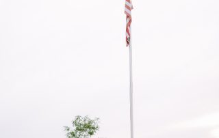 American flag flying over Terrazza Greenfield's scenic grounds, overlooking the golf course landscape.